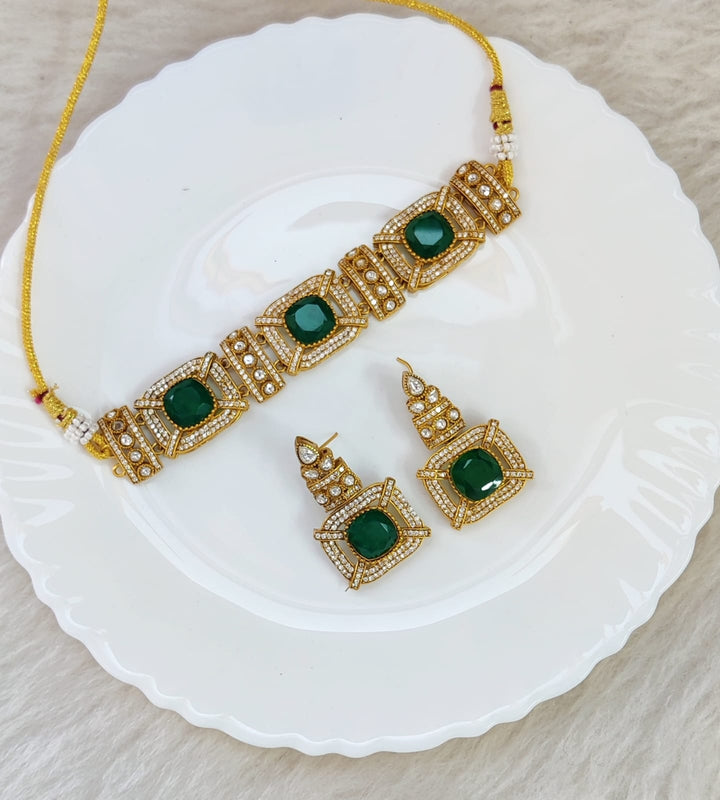 Model wearing a Forest Gem Choker with deep green crystals and gold-plated chain against a white neckline